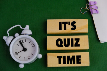 the words Quiz Time beside mini alarm clock on a plain background. the concept of answering quizzes...