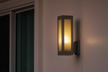 Outdoor wall lantern illuminating home entrance at dusk modern design warm glow effect