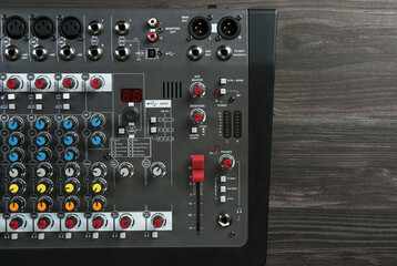 Professional mixing console on wooden table, top view. Space for text