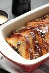 Freshly baked bread pudding in baking dish on table, closeup