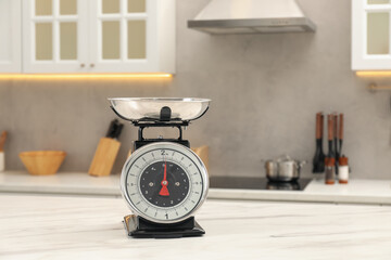 Retro mechanical kitchen scale on white marble table indoors, space for text