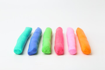 Different colorful play dough on white background, closeup