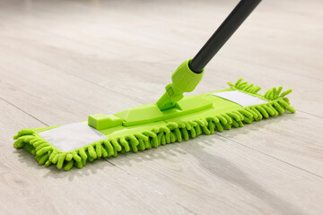 Microfiber mop on wooden floor, closeup. Cleaning equipment