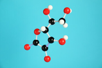 Molecule of vitamin C on light blue background. Chemical model