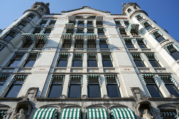 A stunning historic building in Rotterdam with white bricks, reaching skyward. The architecture is richly adorned, featuring statues and towers. Netherlands.