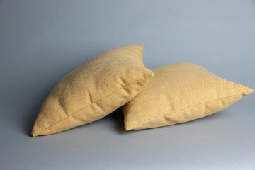 Two soft decorative pillows on grey background