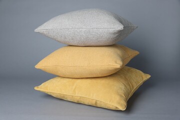 Stack of decorative pillows on grey background
