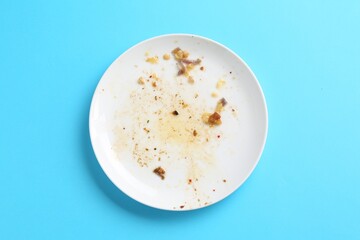 One dirty plate on light blue background, top view