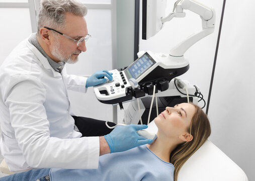 Ultrasound diagnostics of endocrine system and human thyroid. Female patient receives thyroid diagnostics with endocrinologist
