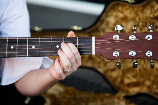 Person playing chords on a guitar