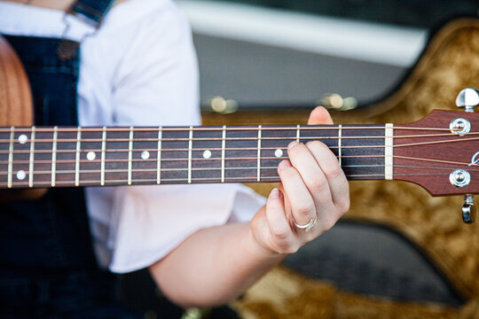 Person playing chords on a guitar
