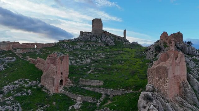 Drone view of the ruins of Xiquena Castle in Lorca, Murcia Region, Spain, with its walls and towers perched on a cliff.