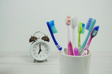 Toothbrush with alarm clock dental hygiene concept on wooden background