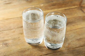 Refreshing soda water in glasses on wooden table, closeup