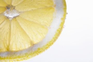 Soda water with lemon slice against white background, closeup