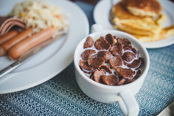Classic breakfast assortment: cereal, sausage, and pancakes. Food.