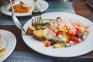 Eating fresh salad with fruits and potatoes, healthy eating