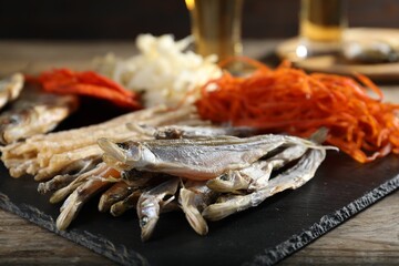 Different dried fish on wooden table, closeup