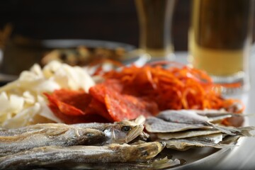 Different dried fish on grey table against black background, closeup