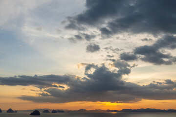 Dramatic sunset over ocean with islands and cloudy sky. Nature