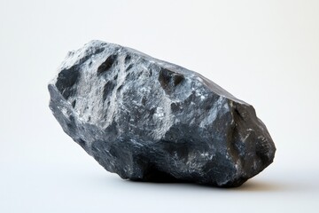 Obraz premium A solitary grey stone rests upon a white background surface