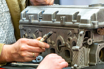 demonstration of replacing spark plugs in an engine block for children. child replacing spark plugs...
