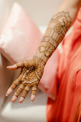 Close-up of intricate henna designs on hands, with palms facing up, showcasing beautiful