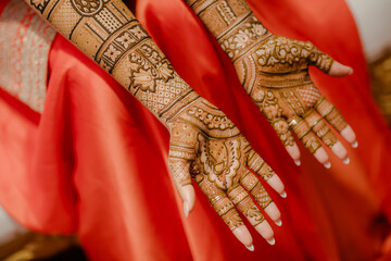 Close-up of intricate henna designs on hands, with palms facing up, showcasing beautiful