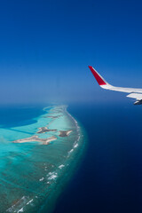 Naklejka premium Scenery view of Maldives islands top view from airplane wing flying in the blue sky above Maldives island
