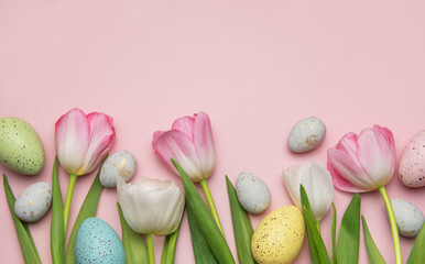 Easter eggs and tulips creating a festive spring border on pink background