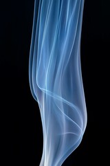 Fototapeta premium Delicate wisps of blue smoke ascending on a dark background
