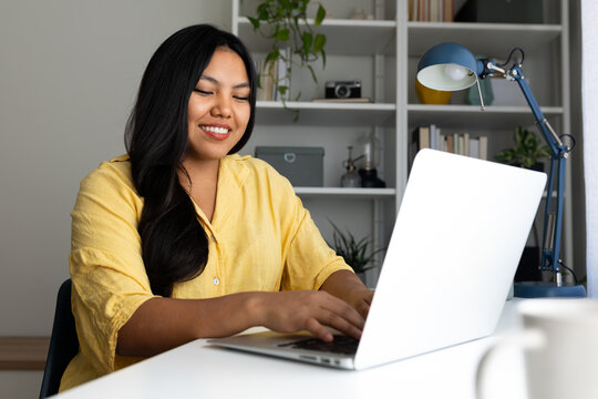 Latin american woman working from home office using laptop computer - Powered by Adobe