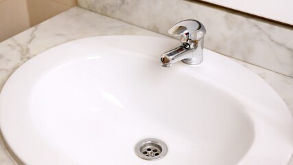 Chrome faucet and white sink in bathroom