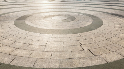 Intricate circular paving pattern crafted from stone tiles, creating a visually appealing background for various purposes.