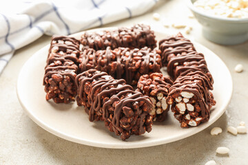 Delicious chocolate puffed rice bars on gray textured table, closeup