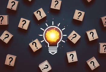 Glowing light bulb from yellow scrap paper among question mark for focus and concentrate of...