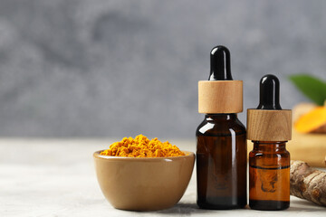 Turmeric oil and powder on grey table, closeup. Space for text
