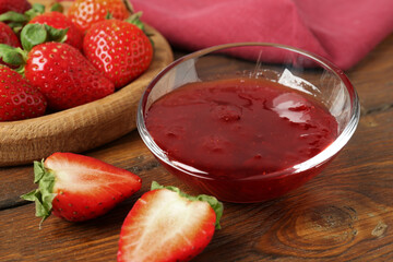 Delicious strawberry sauce and fresh berries on wooden table, closeup