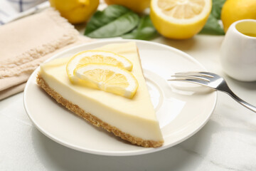 Piece of delicious lemon cheesecake served on white marble table, closeup
