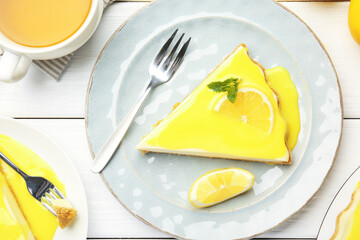 Piece of delicious cheesecake with lemon curd served on white wooden table, top view