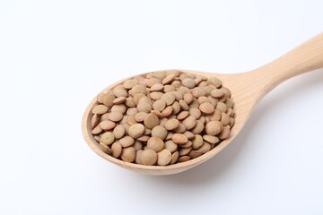 Raw lentils in wooden spoon isolated on white