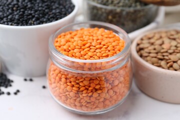 Different types of lentils on white table, closeup