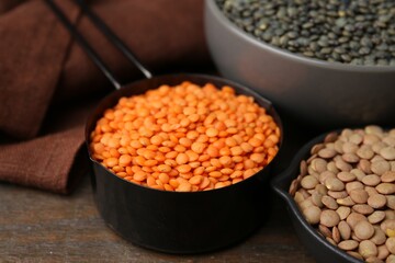 Different types of lentils on wooden table, closeup