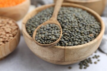 Different types of lentils on light table, closeup