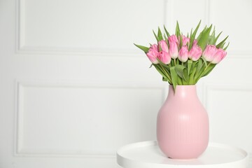 Bouquet of beautiful tulips in vase on white table indoors, space for text