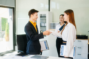 Office colleagues have a casual discussion. During a meeting in a conference room, a group of business teem