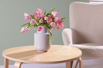 Bouquet of beautiful tulips in vase on table indoors