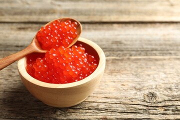 Red caviar on wooden table, closeup. Space for text