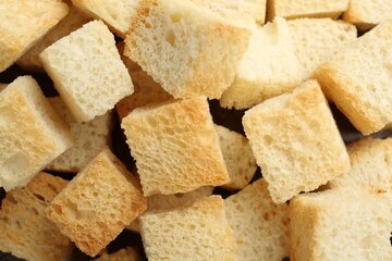 Tasty crispy croutons as background, top view