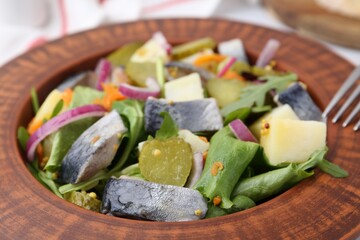 Delicious salad with herring and vegetables on table, closeup